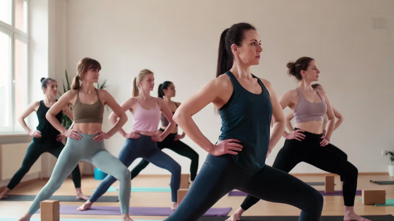 Beginner yoga class with students using blocks and following instructor cues.